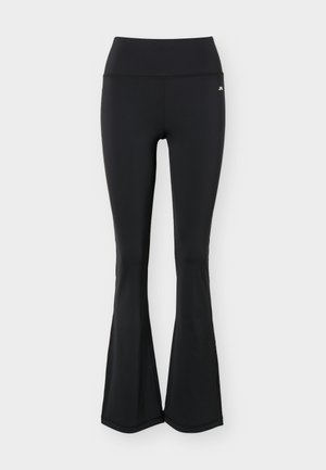 Leggings neri a vita alta con effetto svasato e piccolo logo bianco sull'anca destra, mostrati distesi su uno sfondo chiaro uniforme.