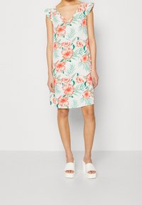 Blumenkleid mit V-Ausschnitt, Rüschenträgern und großen rosa Blumen sowie grünen Blättern auf einem weißen Hintergrund.