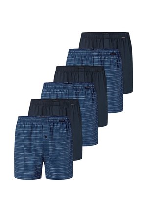 Zes paar herenshorts in afwisselend effen marineblauw en blauw met kleine verticale witte lijnen, gerangschikt in een versprongen rij.