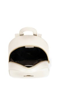 Zaino color crema con forma arrotondata, dotato di una zip dorata e maniglie. L'interno è in tessuto nero senza tasche aggiuntive.