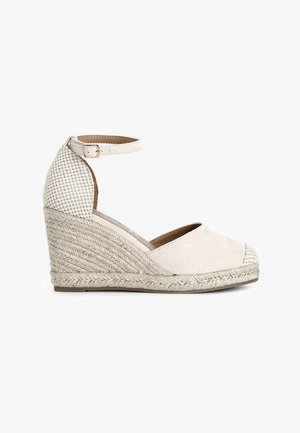 Sandali con zeppa beige, con tomaia in suede, cinturino alla caviglia regolabile e suola intermedia in juta intrecciata. Dettaglio posteriore decorato in una tonalità più chiara.