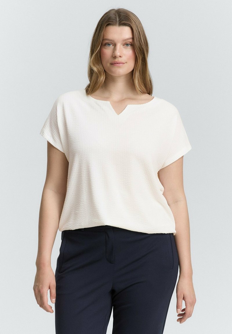 Licht getextureerde, crèmekleurige top met een V-halslijn en korte mouwen, gecombineerd met donkerblauwe broeken. Casual pasvorm, minimalistisch ontwerp.