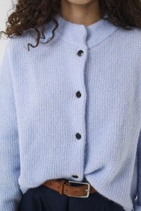 Světlomodrý pletený cardigan s žebrovanou texturou, kulatým límcem, pěti černými knoflíky a hnědým pásem v pase.