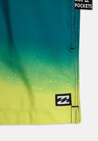 Boardshorts in een teal naar geel kleurverloop, gemaakt van sneldrogend materiaal. Kenmerken zijn zijzakken en een gestikte logodetail.