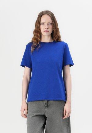 Blue cotton t-shirt featuring a crew neck, short sleeves, and a relaxed fit, paired with gray high-waisted pants.