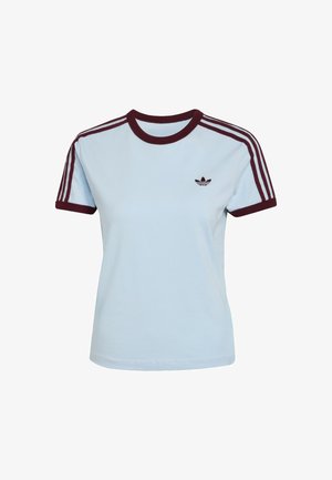 Vaaleansininen puuvillainen t-paita, jossa burgundinsävytteinen joustinneuloskaulus ja hihansuut. Olkapäillä kolme burgundinsävyistä raitaa ja rintakehällä logo.