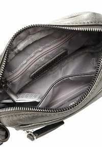 Metalická stříbrná taška se hladkým textilním podšívkou, několika přihrádkami a kapsou na zip. Disponuje šedými texturovanými akcenty.