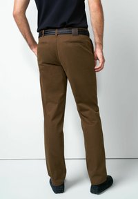 Bruine geruite broek met rechte snit, voorzien van zijzakken en een zwarte geweven riem. Glad stof met een getailleerde pasvorm.