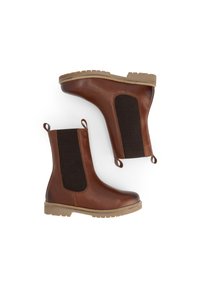 Een paar bruine leren Chelsea boots met zwarte elastische zijpanelen en tan rubberen zolen op een witte achtergrond.