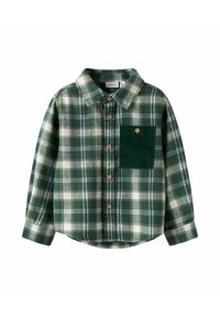 Grønn rutete flanellskjorte med hvite og gule detaljer, knappelukking foran, og en teksturert grønn kordfløyelslomme på venstre bryst.