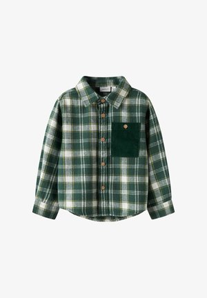 Grön rutig flanellskjorta med vita och gula accenter, knappknäppning fram och en texturerad grön manchestermudd på vänster bröstficka.