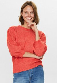 Maglione in coral con scollo rotondo e maniche a palloncino, caratterizzato da una finitura testurizzata. Abbinalo a jeans blu.