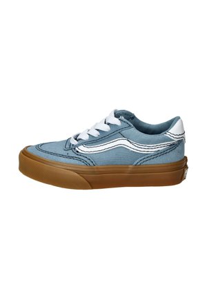 Zapatilla de lona azul con cordones blancos, costuras perfiladas y suela de goma marrón. Presenta un diseño clásico de corte bajo.