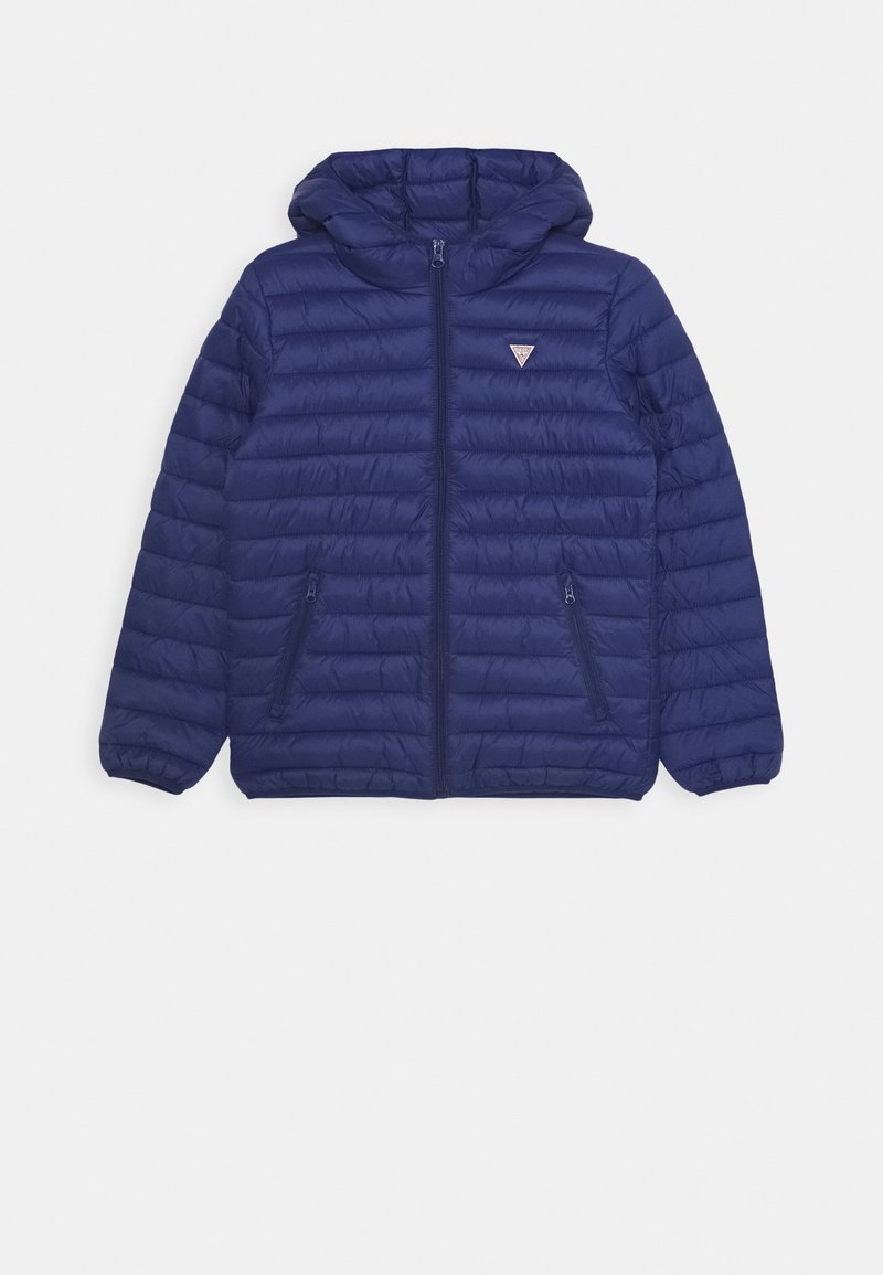 Veste matelassée à capuche bleu marine avec fermeture éclair devant et deux poches latérales zippées, avec un petit logo triangulaire sur la poitrine.
