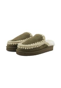 Pantofole verdi in suede con un morbido rivestimento bianco, dotate di un bordo intrecciato e di una suola piatta in gomma. Texture morbida e forma arrotondata.