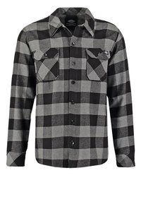 Camisa de franela de cuadros en negro y gris con botón frontal, dos bolsillos en el pecho y un cuello. Tejido texturizado con un diseño clásico.