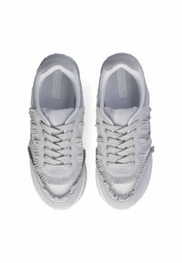 Sneaker grigi con tomaia in tessuto testurizzato e sfrangiato, punta rinforzata e numerosi passanti per i lacci. La suola è leggermente rialzata e liscia.