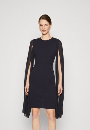 Robe bleu marine en tissu extensible, avec des manches transparentes trois-quarts et une silhouette ajustée avec un col rond.