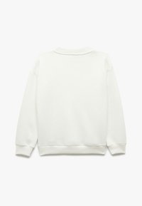 Sudadera blanca con cuello redondo, puños y dobladillo acanalados, confeccionada en un tejido suave y texturizado, con un corte holgado y un diseño minimalista.
