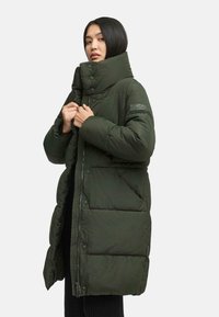 Long green puffer coat with a high collar, featuring large buttons, a textured patch on the sleeve, and a zippered front.