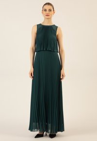 Falten-maxikleid in tiefgrün, mit ärmellosem Design, geschichteter Brustpartie und fließendem Rock. Sanfte Textur und dezenter Glanz.