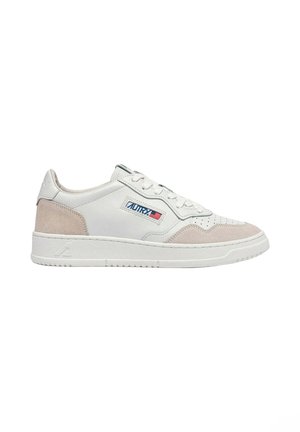 Sneaker bianco low-top con dettagli in suede beige, chiusura con lacci e patch logo con bandiera americana sul lato.