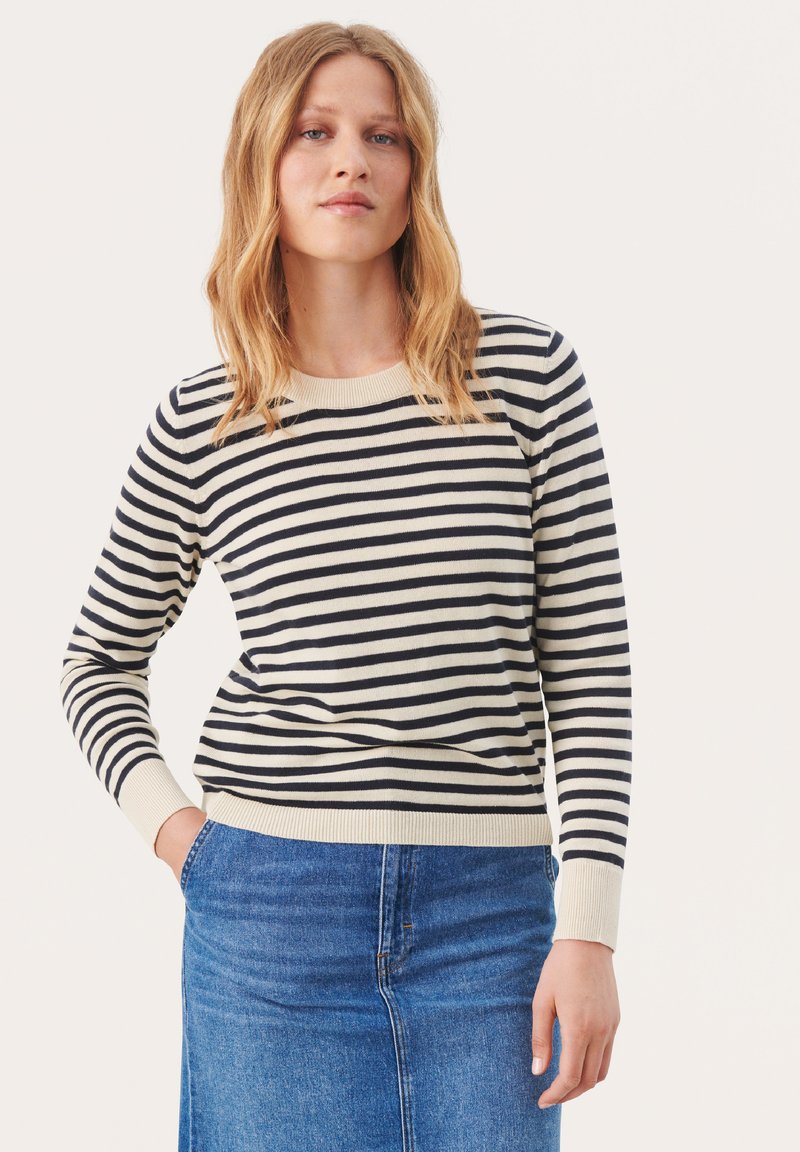 Maglione a righe in crema e blu navy con maniche lunghe, collo a giro e polsini a coste. Abbinalo a una gonna di jeans blu.