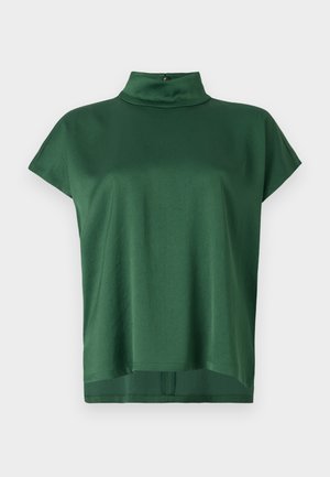 Top verde de manga corta con cuello alto, hecho de una tela suave. Cuenta con un corte relajado y un brillo sutil, con un cierre en la parte posterior del cuello.