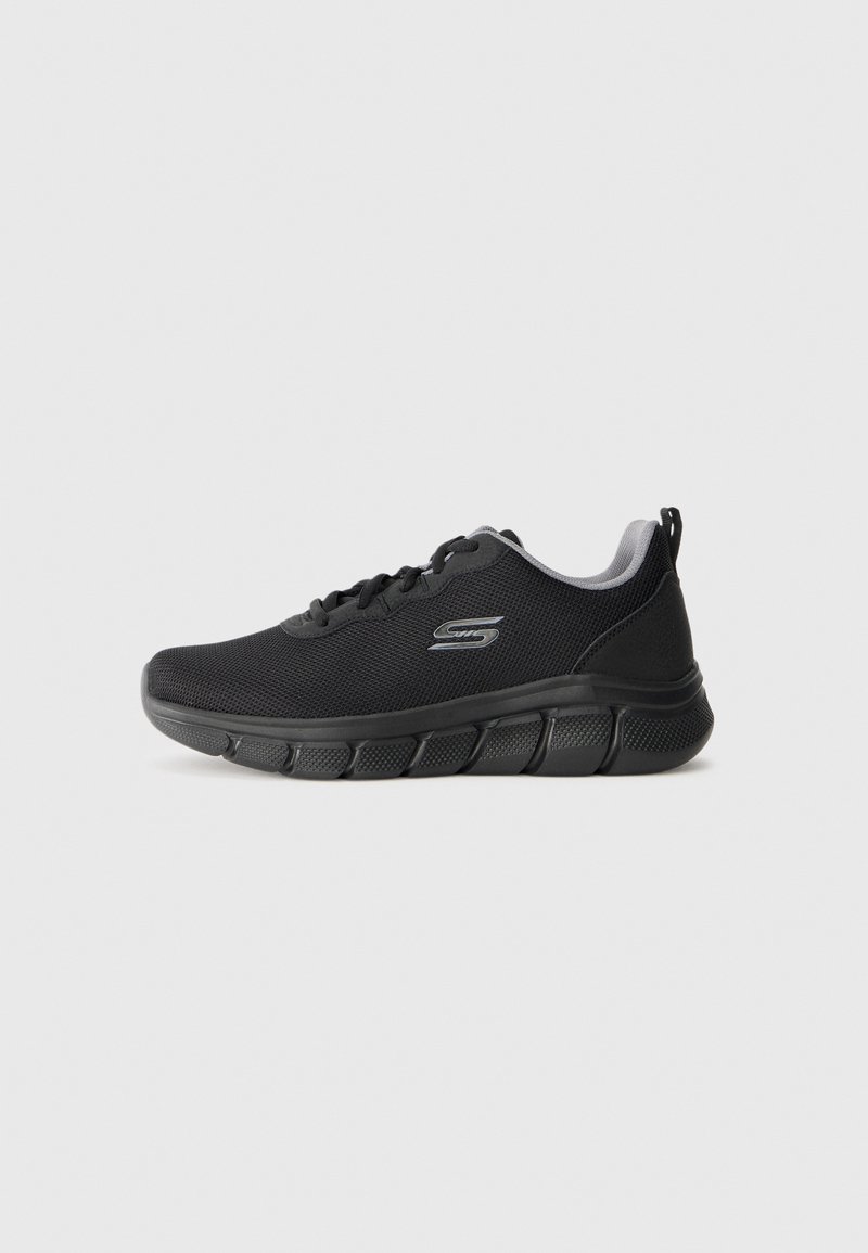 Black athletic shoe with a textured mesh upper, padded collar, and a flexible rubber sole featuring segmented grooves for traction.