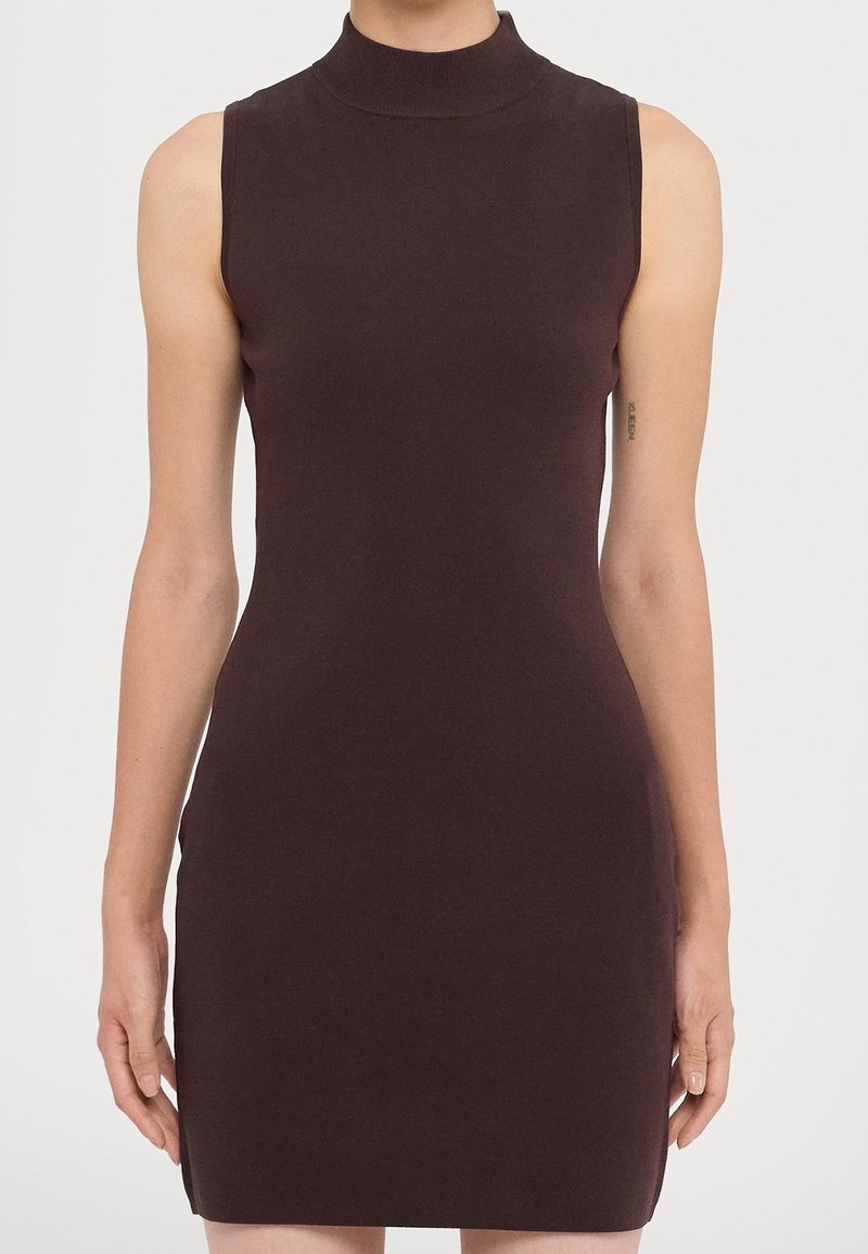 Figurformad ärmlös klänning i mörkbrunt, med hög halsringning och slät yta som följer kroppen utan ytterligare dekorationer.