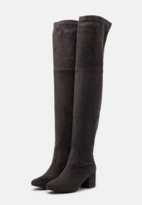 Stivali alti fino alla coscia, in suede grigio scuro con una texture liscia, punta affusolata e tacco a blocco. Dettaglio di cucitura alla parte superiore del gambale.