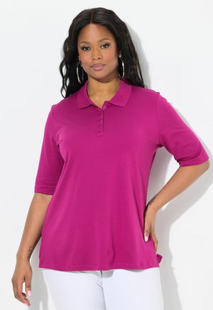 Magenta poloshirt met een kraag, korte mouwen en een knoopsluiting. Soepele textuur en relaxte pasvorm, met zijsplitten.