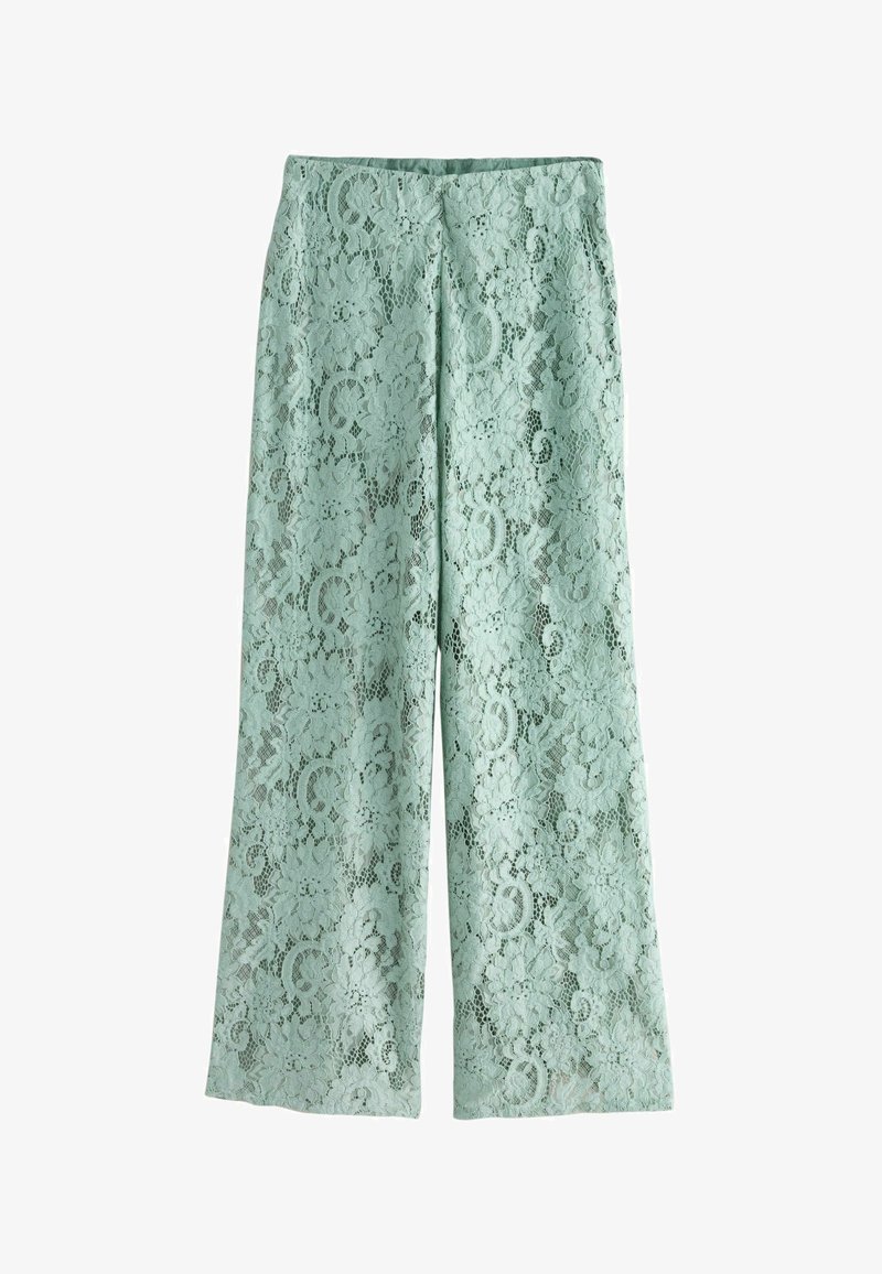 Pantalon ample vert clair avec superposition en dentelle florale et taille haute, posé à plat sur un fond blanc.