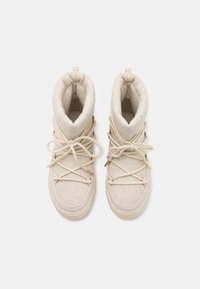 Bottes beige jusqu'à la cheville avec une doublure en polaire douce, un design à lacets et une semelle en caoutchouc lisse. Comprend des accents en cuivre et une surface supérieure texturée.