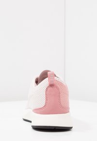 Lättviktig sneakers med en ventilerande mesh-överdel i vitt med rosa mockadetaljer, en dämpad häl och en svart gummisula.
