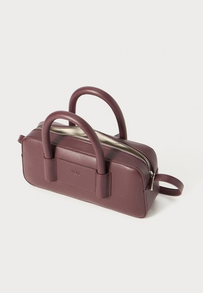 Μαυρού τσάντα χεριού από δέρμα με δύο στρογγυλές λαβές, φερμουάρ κλεισίματος και ορθογώνιο σχήμα. Διαθέτει λείο υφή και διακριτική λεπτομέρεια μάρκας στη πλευρά.