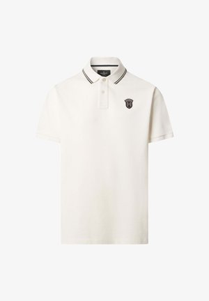 Polo i offwhite bomuld med en sort stribe på kraven. Har et lille broderet emblem på venstre bryst. Korte ærmer.