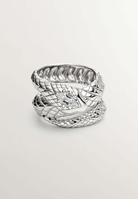 Anillo en forma de serpiente plateada con un diseño texturizado y escamoso, que presenta una piedra preciosa ovalada y clara en la parte frontal. Acabado interior suave.