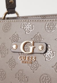Geantă de mână gri, cu un model de logo embosat, accesorii de nuanță aurie și un emblema centrală G. Material sintetic texturat cu un finisaj neted.
