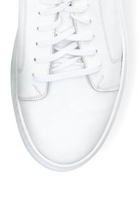 Białe skórzane trampki z teksturowaną cholewką, płaskimi sznurówkami i zaokrąglonym noskiem. Posiadają minimalne przeszycia i gładką gumową podeszwę.