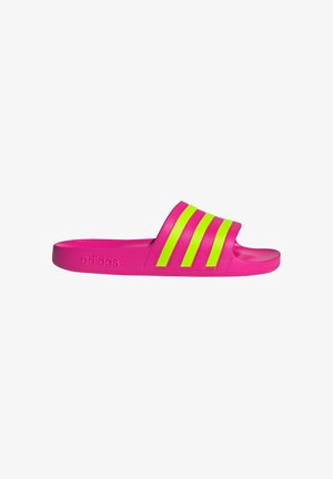 Adidas slide sandals in bright pink, featuring three reflective neon green stripes across the upper, with a flat rubber sole.