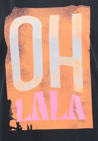 Camiseta negra con un gran texto gráfico en naranja y rosa que dice "OH LA LA" en un estilo atrevido y desgastado. Material de algodón suave.