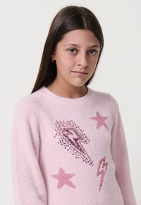 Maglione rosa, morbido e vaporoso, con design di fulmini e stelle in paillettes, dotato di scollo a giro e maniche lunghe. Texture morbida.