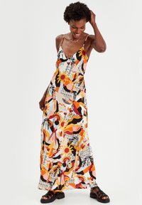 Abito maxi in tessuto leggero con un vivace motivo astratto dai toni arancioni, rosa e neri. Spalline regolabili.