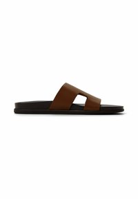 Hnědé kožené sandály na klínku bez opasku se širokým páskem s výřezovým designem, spočívající na ploché černé podrážce pro minimalistický styl.