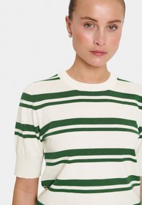 Gebreide trui met korte mouwen in crèmekleur met groene horizontale strepen en witte accenten. Beschikt over een ronde halslijn en een zachte textuur.