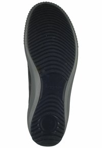 Suola di scarpa in gomma con una superficie nera texturizzata, caratterizzata da scanalature orizzontali e un'indentazione circolare vicino al tallone.