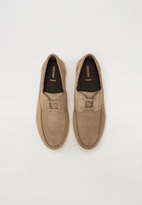 Pantofi bej din suede cu vârf rotunjit, detalii cusute și design cu sireturi. Dispune de o branț respirabil și o construcție ușoară, casual.