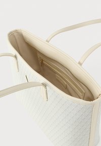 Borsa a tracolla color crema con motivo a diamante strutturato, apertura superiore, due manici e tasca interna con zip. Foderata in tessuto beige.