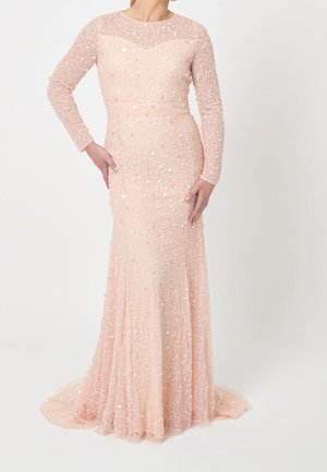 Mujer con vestido largo hasta el suelo de manga larga en color rosa melocotón, adornado con lentejuelas, ajustado en la cintura y caderas, que se abre ligeramente hacia el dobladillo.